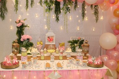 Una mesa dulce y una estructura de globos rosa y dorado para la ...