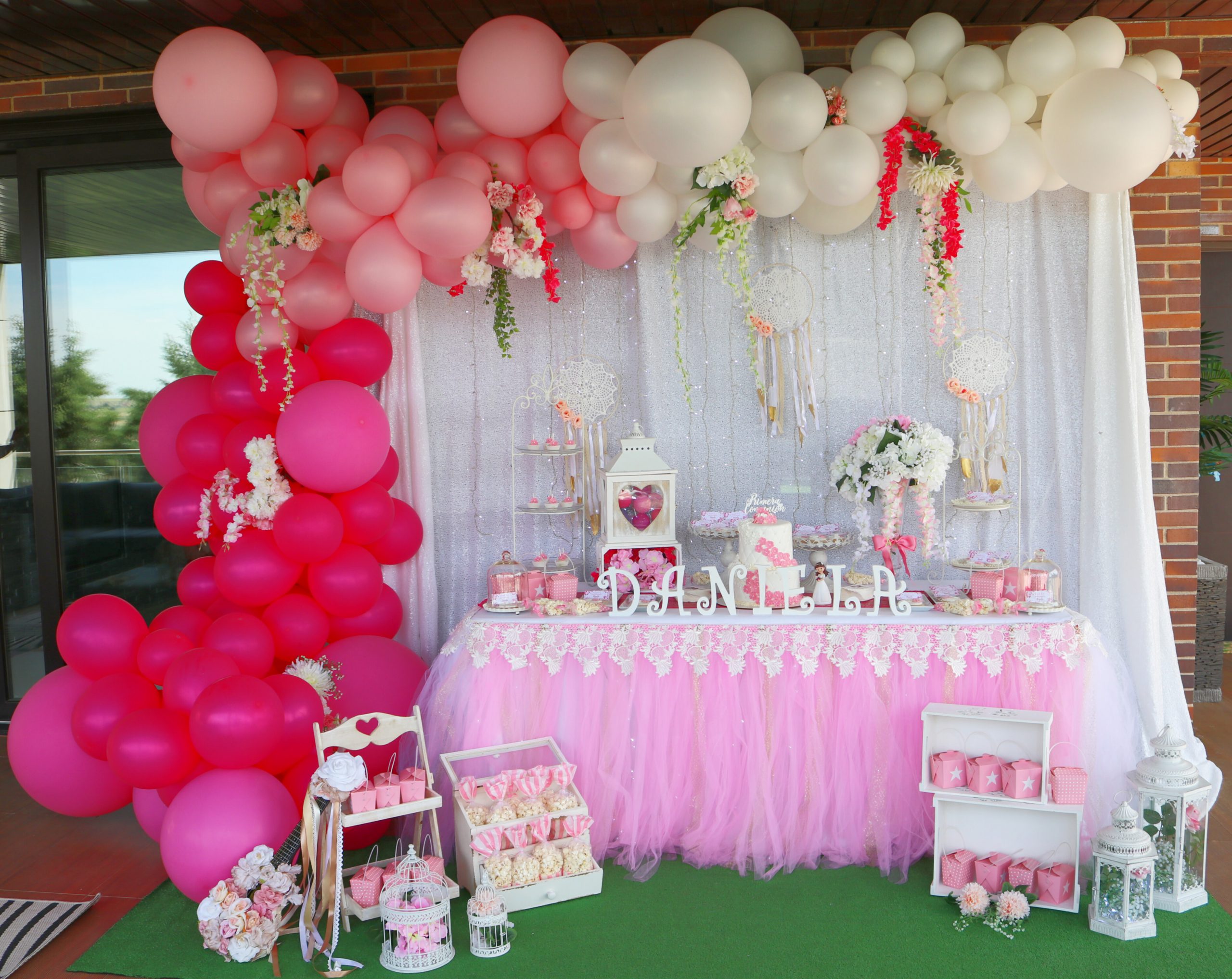Mesa dulce decorada con globos y flores en colores blanco y rosa